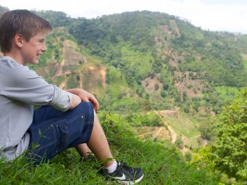 Middle school aged boy looks at vista of Costa Rican fields
