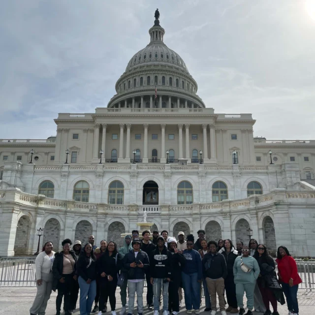 Students from our school group travel program pose for a photo in front of the U.S. Capitol building on a sunny day.