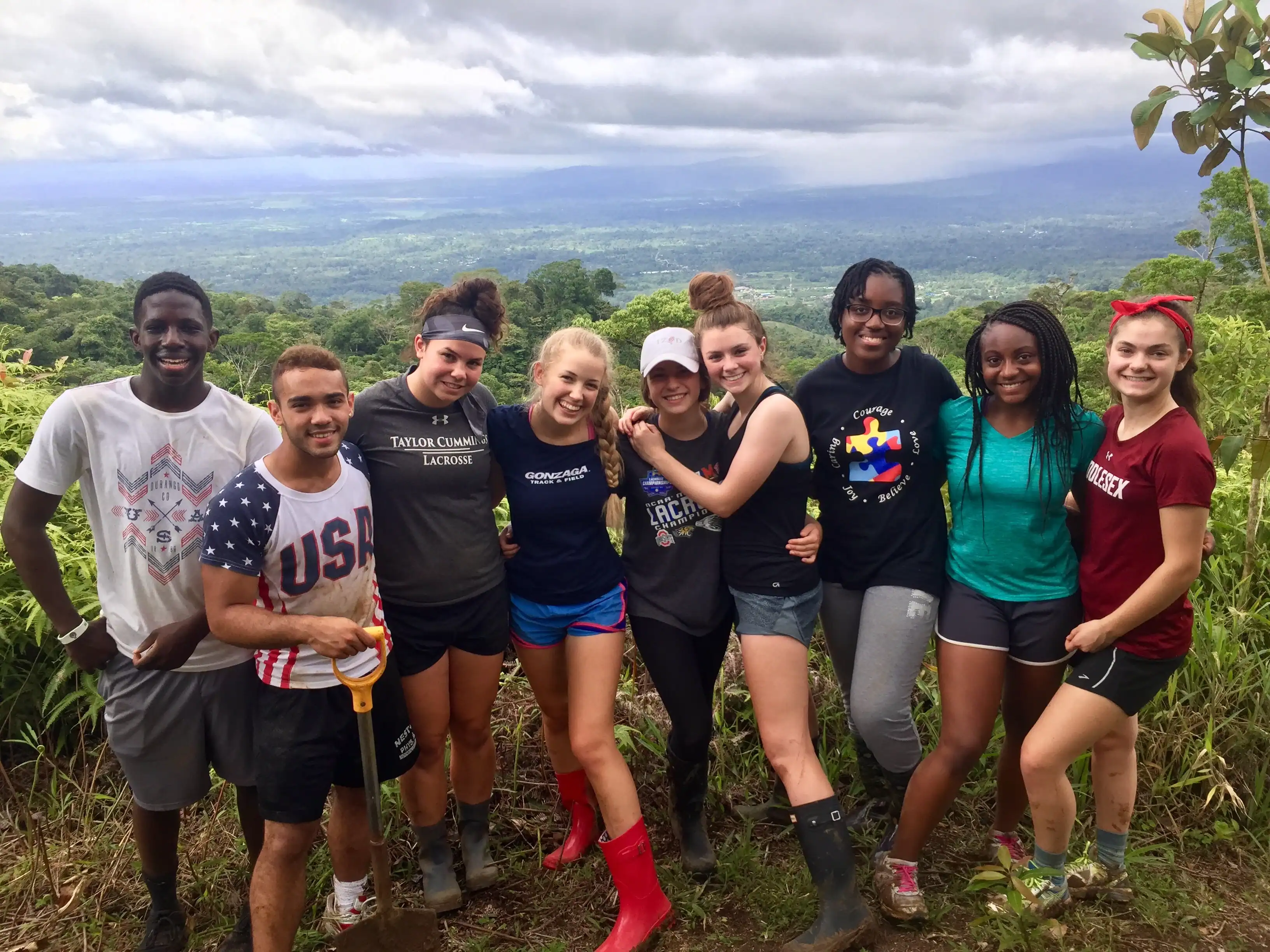 A group of teens smile together on a grassy hilltop in Costa Rica during a Global Works summer trip.
